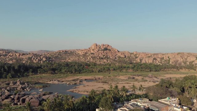 Rocky landscape and barren Tungabhadra Riverbank at Hampi town's edge, Karnataka, India - Aerial  Panoramic shot