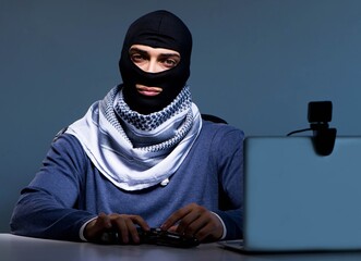 Hacker wearing balaclava mask hacking computer