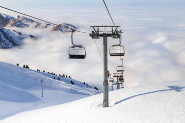 Fototapeta na wymiar Winter mountains panorama with ski slopes and ski lifts near Almaty city. Winter vacation concept