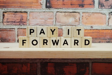 Fototapeta na wymiar Pay It Forward alphabet letter on old brick wall and wooden shelves background