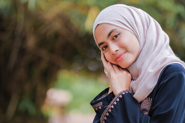 Young Asian Muslim woman smile to the camera.