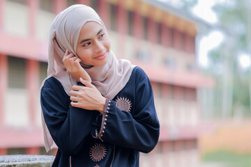 Young Asian Muslim woman smile to the camera.