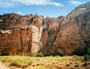 Unbelievable sandstone cliff and superlative domes with tumbleweeds on a hot summer partly cloudy day in Capitol Reef National Park in Southern Utah