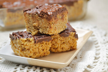 A close up of three rice krispie treats on a plate.