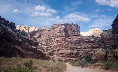 Unbelievable sandstone cliff and superlative domes with tumbleweeds on a hot summer partly cloudy day in Capitol Reef National Park in Southern Utah
