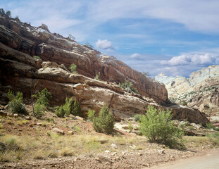 Unbelievable sandstone cliff and superlative domes with tumbleweeds on a hot summer partly cloudy day in Capitol Reef National Park in Southern Utah