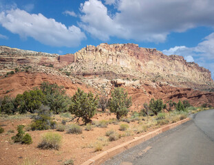 Unbelievable sandstone cliff and superlative domes with tumbleweeds on a hot summer partly cloudy day in Capitol Reef National Park in Southern Utah