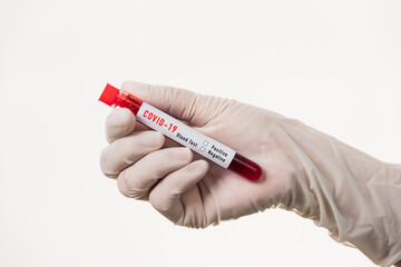 Obraz premium Doctor scientist in white uniform wear a mask holding test tube Coronavirus test blood sample in a clinical laboratory for analyzing isolated on white, medicine COVID-19 pandemic outbreak concept
