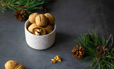 Walnuts unpeeled in a white Cup on a dark background in a Christmas atmosphere.