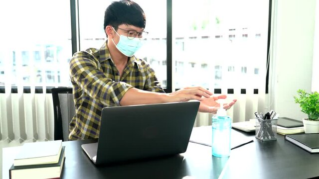 Asian Businessman In Glasses Wearing Protective Hygiene Mask Working On Laptop In Office For People Protect Themselves Coronavirus Pandemic, Covid 19 Quarantine