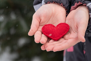 Female hands giving red handmade heart outdoor