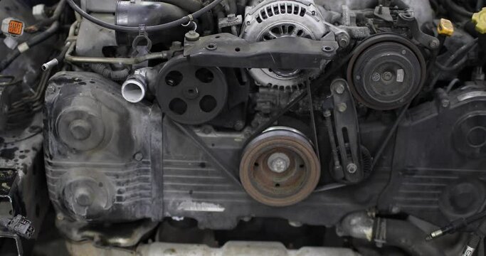 Car repair and maintenance workshop. Closeup of car engine chain and gears, closeup view, camera is moving away from it. Production and repair of engines for used and new cars.
