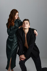 A man knelt down and a sexy woman in an evening dress