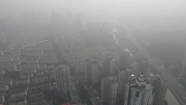 City in heavy haze and air pollution. Building and roads in fog in day time. Environmental conservation and air pollution issues concept b-roll footage. Highly polluted residential area Shanghai China