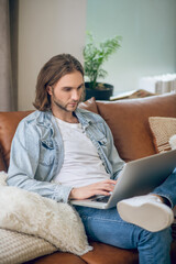 Man in jeans shirt working and looking involved