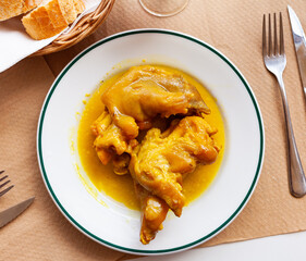 Traditional Spanish braised pettitoes, spicy pig feet cooked with sauce..