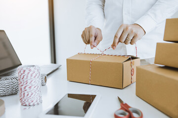 Young asian teenage product owners are packing small business packaging products in boxes prepared...