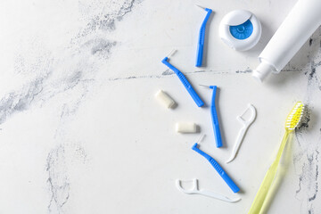 Toothbrushes for dental braces, floss and paste on light background