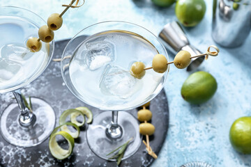 Glasses of fresh martini on color background