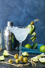 Glass of fresh martini on color background
