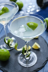 Glasses of fresh martini on color background