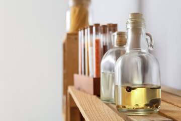 Glass bottles with oil and spices on kitchen shelf