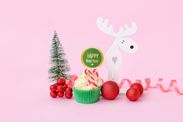 Tasty Christmas cupcake and decor on color background
