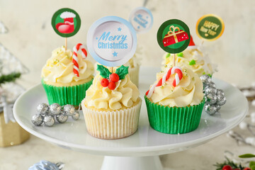 Dessert stand with tasty Christmas cupcakes on table