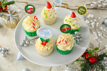 Dessert stand with tasty Christmas cupcakes on table