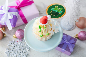 Dessert stand with tasty Christmas cupcake on table