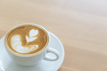 A cup of tulip latte art coffee on wood table background
