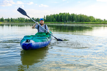 a man with a beard in an inflatable boat swings an oar
