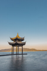 Fototapeta premium Sunrise view of Jixian pavilion, the landmark at the west lake in Hangzhou, China.