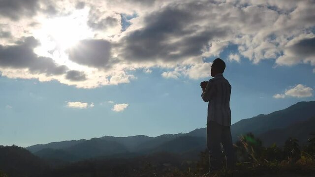 A man standing on a mountaintop praying