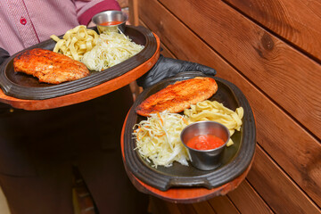 Grilled chicken breast with macaroni and sauce. Waiter serving sinner at restaurant, waiter at work.