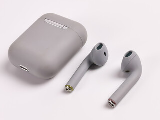 Selective focus picture with noise effect white background with grey color ear buds.Slightly blur at the back.