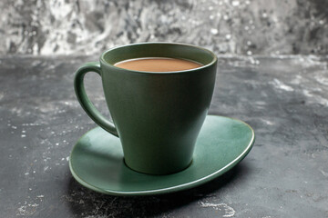 Vertical view of delicious coffee in a green cup on gray background