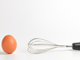 A chicken egg with egg beater isolated on white background.