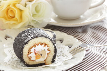 homemade mango Swiss roll in black color and tea