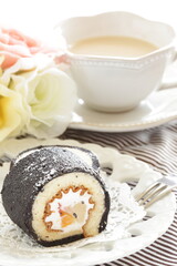 homemade mango Swiss roll in black color and tea
