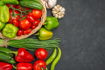 Above view of fresh various organic vegetables in wicker basket on dark background