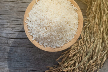 rice in bowl.
Beautiful white jasmine rice inside the cup rests on the old wooden floor and rice.