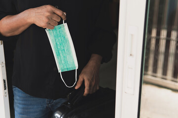 Adult working woman getting ready with surgery mask and luggage bag to go out for a travel trip while Coronavirus COVID-19 pandemic. healthcare concept