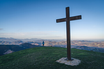 Cross on the top of the mount at sunset light, sunny alpine landscape, Mountaineering, trekking