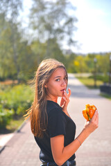 Woman eating burger and fries smiling. Beautiful caucasian female model eating a hamburger with hands.