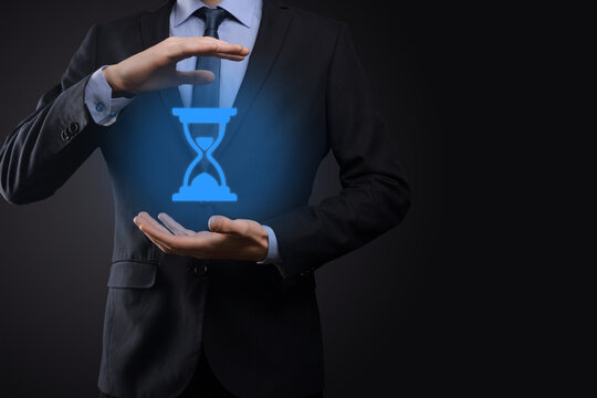 Businessman man holds in hand hourglasses icon. Time expires. A reminder to action. Business concept. Elements for design.