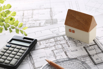 木でできた家の模型とマイホームの設計図のイメージ