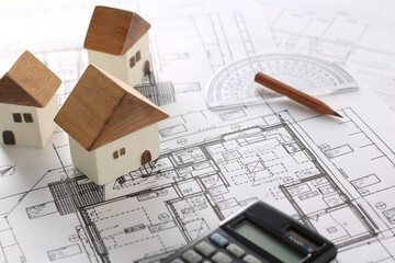 木でできた家の模型とマイホームの設計図のイメージ