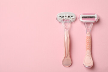 Two razors on pink background, space for text