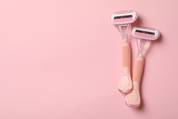 Two razors on pink background, space for text